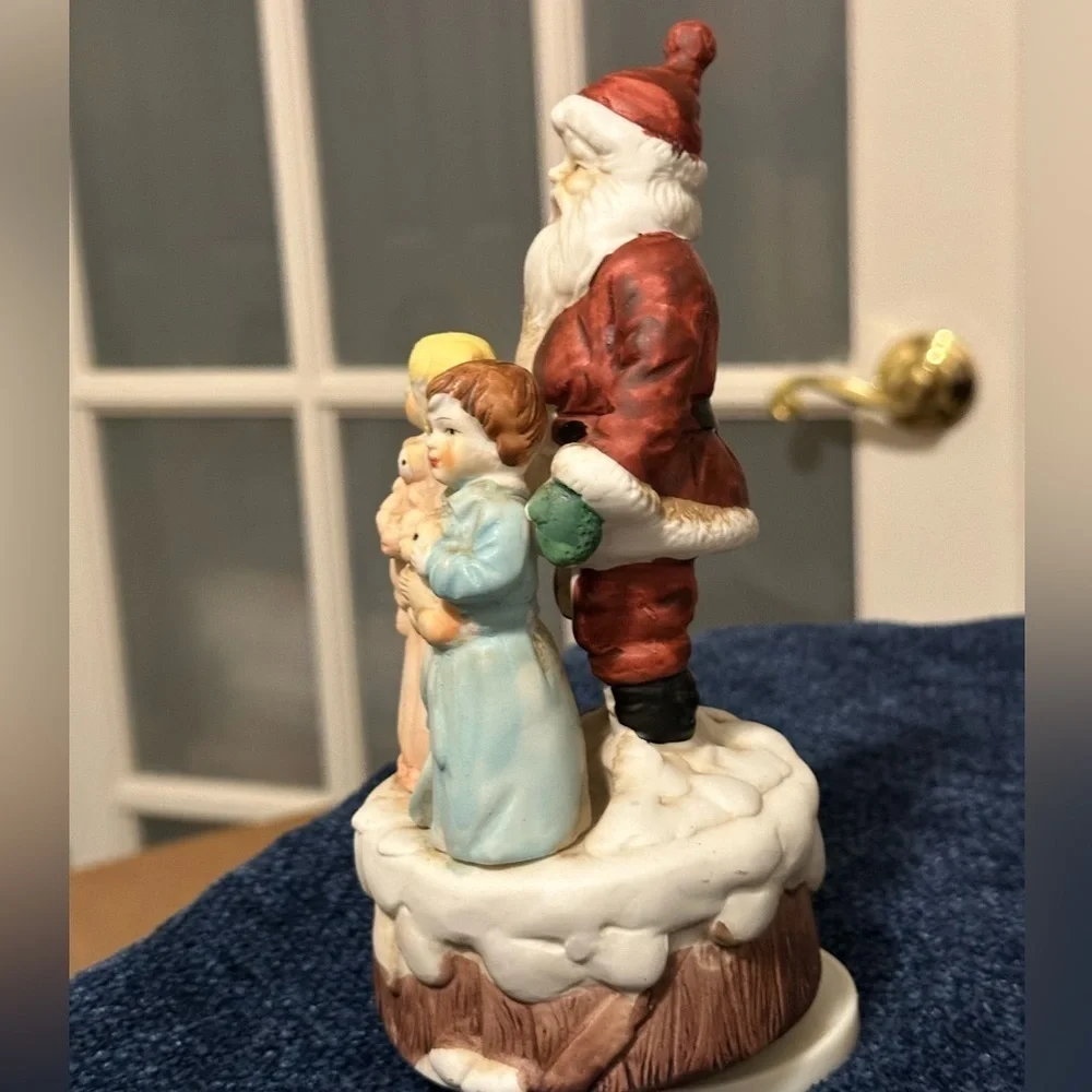 Beautiful Santa hugs 2 small children and plays Santa Claus is Coming to Town.